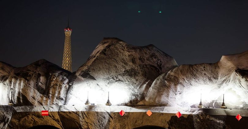 french artist jr begins his giant cave art inflation over paris oldest bridge