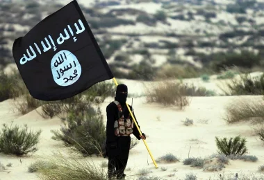 masked islamic state soldier poses holding the isil banner in the desert 2015