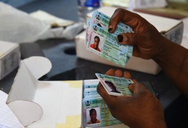 Officials of the Independent National Electoral Commission INEC sit to distribute Permanent Voter Ca