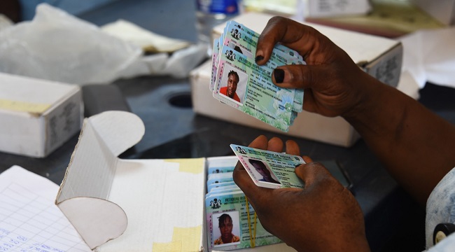 Officials of the Independent National Electoral Commission INEC sit to distribute Permanent Voter Ca
