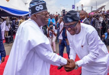 President Bola Tinubu and FCT Minister Nyesom Wike in a warm handshake during an event